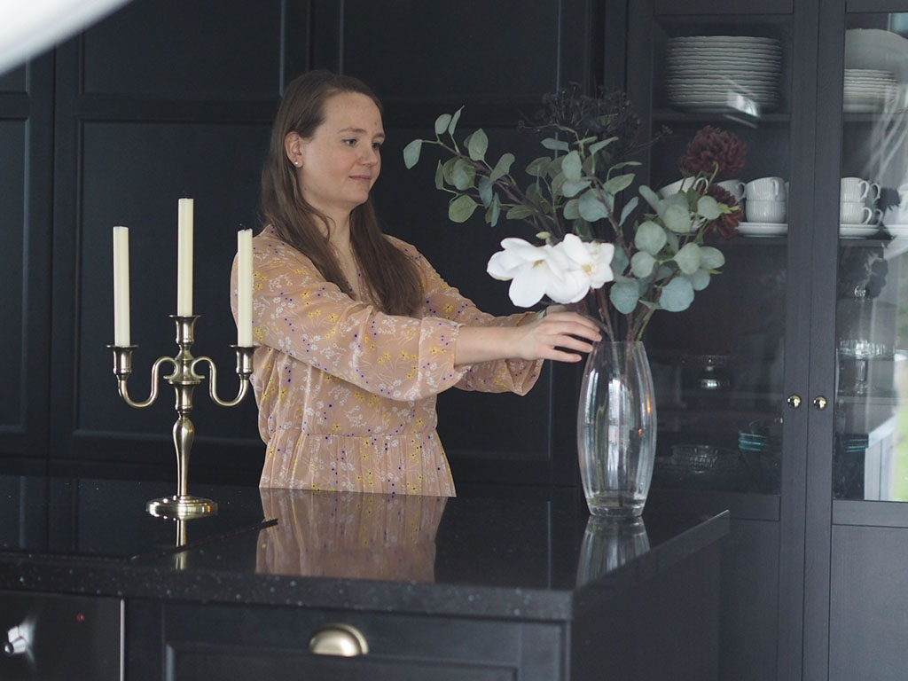 Heidi asettelemassa kukkia maljakkoon. Kuvituskuva.